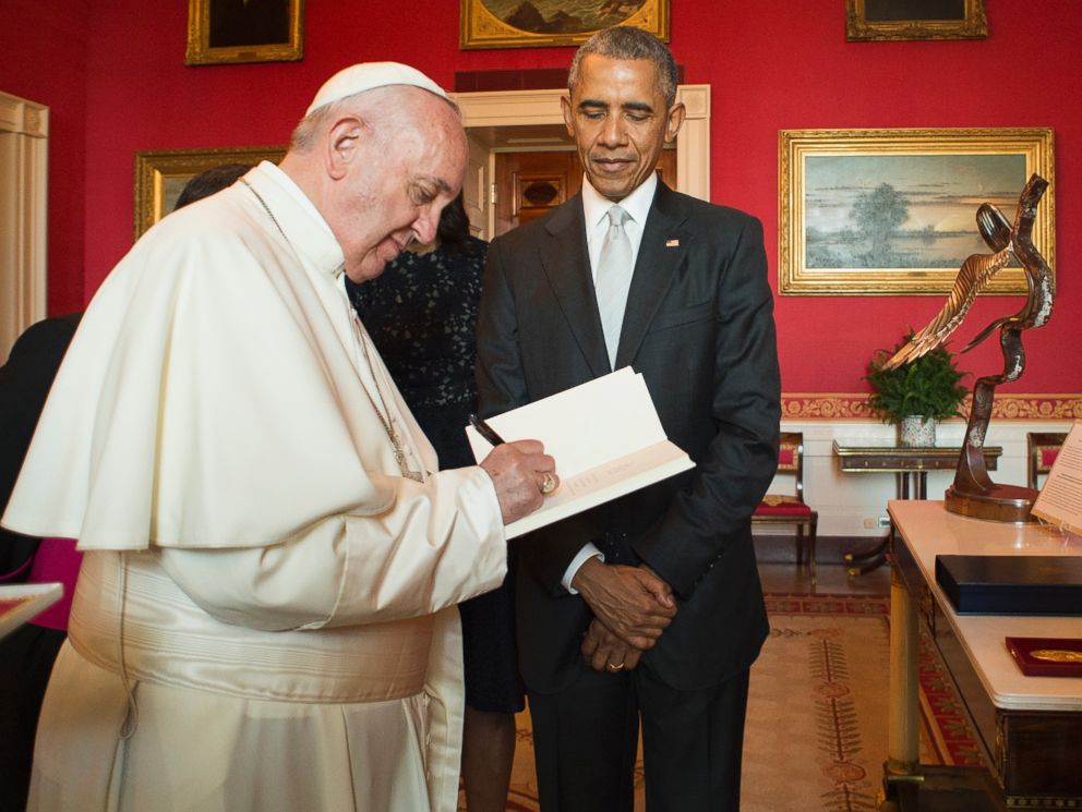 PHOTO: In this photo provided by LOsservatore Romano, Pope Francis signs a guest book as President Barack Obama looks on at the White House in Washington, Sept. 23, 2015.